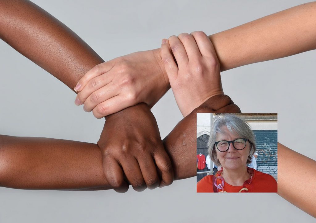 white Caucasian female hands and black African American holding together in world unity and racial love and understanding in tolerance and races diversity cooperation concept